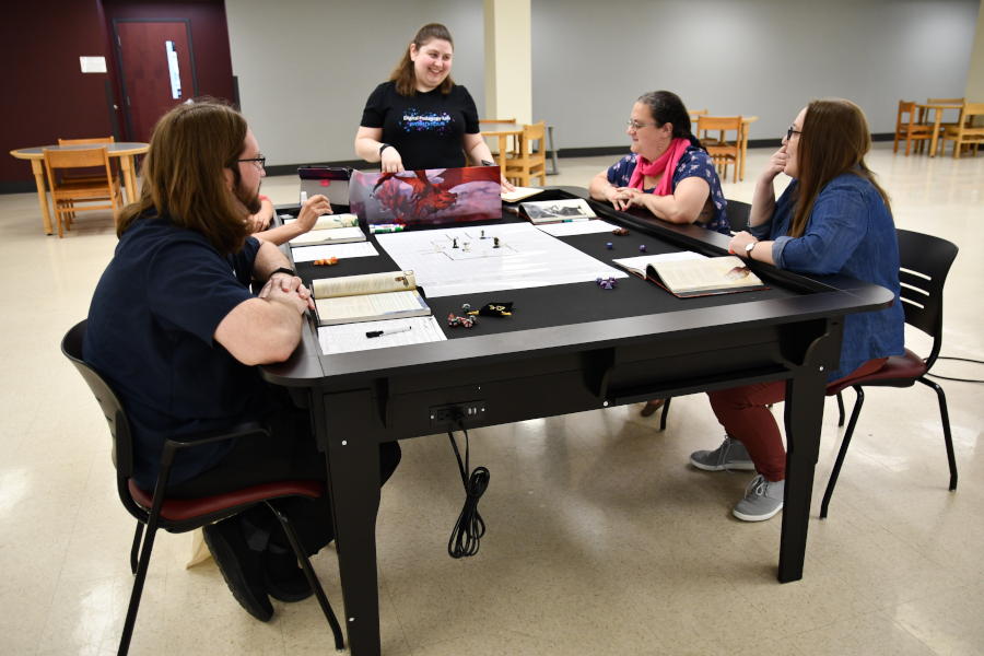 Photo of people seated at a gaming table laughing